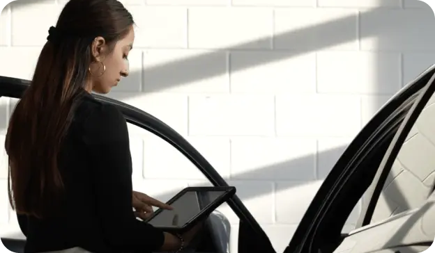 woman next to car with tablet