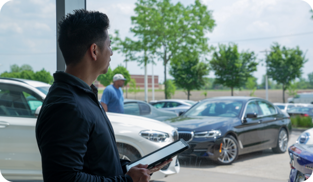 Salesperson looking at car lot